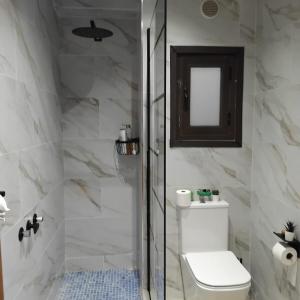 a bathroom with a toilet and a glass shower at Beach Apartment in Puerto de Mazarrón +26 photos