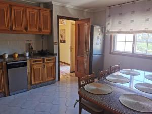 Una cocina con mesa y sillas y un refrigerador. en Saians Vigo Mar, en Vigo