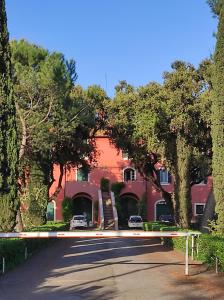 un edificio rojo con árboles frente a una calle en The Farm House - Fast WiFi - Free Parking, en Ponte Lucano