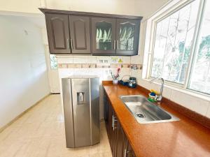 a kitchen with a stainless steel refrigerator and a sink at Cabaña Yopal - Yopo Resort in Yopal +14 photos