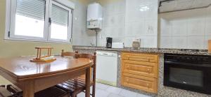 a kitchen with a wooden table and a counter top at Casa Pilar, Ribadesella in Ribadesella