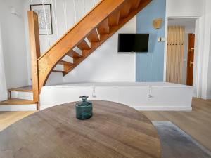 a vase sitting on a table in a room with a staircase at Duplex cosy idéal pour familles à 200m de la plage in Blonville-sur-Mer