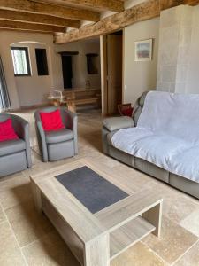 a living room with a couch and two chairs and a coffee table at Gite le Roucayral , vue imprenable sur St Cirq Lapopie, deux chambres climatisées in Tour-de-Faure