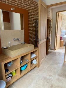 a bathroom with a sink and a brick wall at Gite le Roucayral , vue imprenable sur St Cirq Lapopie, deux chambres climatisées in Tour-de-Faure +40 photos