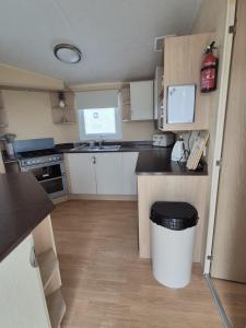 eine kleine Küche mit einem Mülleimer in der Mitte in der Unterkunft Meadow Lakes 64, pet friendly , WiFi & bed linen - Golden Palm Resort - Meadow Lakes Caravan & Lodge Hire in Chapel Saint Leonards