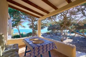a table on a porch with a view of the ocean at Meridium Formentera by Tentol Hotels in Playa Migjorn