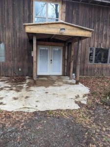 a garage with a blue door in front of a building at Tug Hill Fisherman's Paradise Rural and Quiet - Downstairs in Lacona