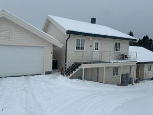Una casa con una entrada cubierta de nieve en frente de ella. en Kvaløya Seaview, en Tromsø