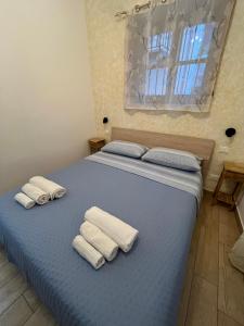 a blue bed with towels on top of it at Spinuzza relax in Cefalù