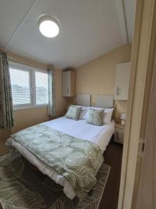 ein Schlafzimmer mit einem großen Bett in einem Zimmer in der Unterkunft Meadow Lakes 64, pet friendly , WiFi & bed linen - Golden Palm Resort - Meadow Lakes Caravan & Lodge Hire in Chapel Saint Leonards + 3 Fotos