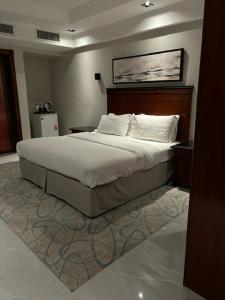 a bedroom with a large bed with white sheets and pillows at ديباج للشقق المخدومة in Dammam