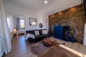 a living room with a black couch and a brick wall at Aurora Schaar 2 in Wilhelmshaven