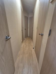 einen Flur mit zwei Türen und Holzboden in der Unterkunft Meadow Lakes 64, pet friendly , WiFi & bed linen - Golden Palm Resort - Meadow Lakes Caravan & Lodge Hire in Chapel Saint Leonards