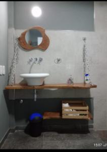 un baño con lavabo y espejo en Lamora, en La Criolla