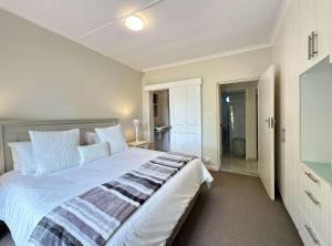 una camera da letto con un letto grande e un bagno di Chalet 33, Silver Ranch, Plettenberg Bay a Plettenberg Bay