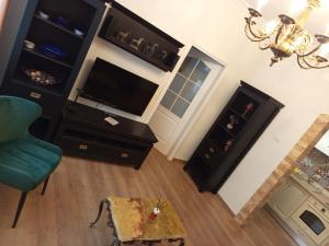 a living room with a television and a chair at Toni s Luxury Central Place in Braşov