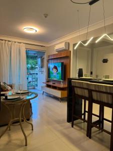 a living room with a table and a tv in it at Apartamento 207 varias piscinas in Bombinhas
