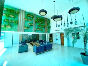 a lobby with blue furniture and a potted plant at Flamboyant Oceania Flats in João Pessoa