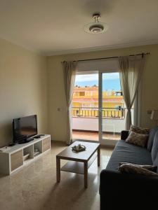 salon z kanapą i telewizorem w obiekcie Tenerife PLAYA LA ARENA w mieście Puerto de Santiago