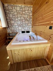 a bathroom with a tub with a stone wall at Ayder Defne Suit Ev in Çamlıhemşin +5 photos