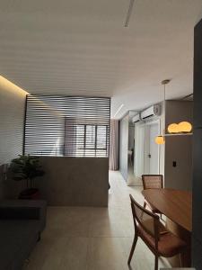 a living room with a table and a dining room at Apartamento Loft Lazer Completo in Belo Horizonte