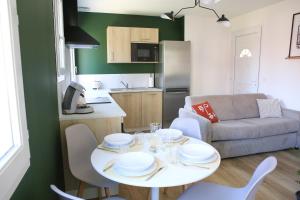 a kitchen and a living room with a table and chairs at Appartement T2 cosy in Roussillon en Isere