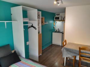 a small room with a table and a kitchen at Studio avec terrasse in Donges