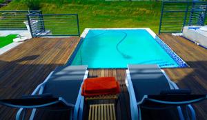 a swimming pool on top of a deck with chairs at Greenlake Guesthouse in Maseru