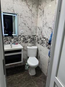 Un baño con inodoro, lavabo y espejo. en ana-Apartament, en Kobuleti 11 fotos más