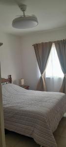 a bedroom with a bed and a window at La posada de Lily in La Punta