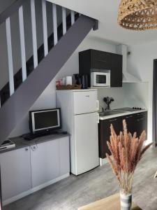 a kitchen with white cabinets and a staircase at Terrasses du lac appt in Aureilhan