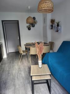 a living room with a blue couch and a table at Terrasses du lac appt in Aureilhan
