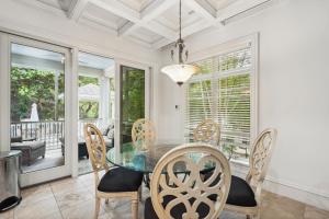 a dining room with a glass table and chairs at 340 Low Oak Woods Road by Akers Ellis Rentals in Kiawah Island