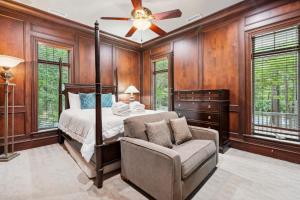 a bedroom with a bed and a chair and a ceiling fan at 340 Low Oak Woods Road by Akers Ellis Rentals in Kiawah Island +44 photos