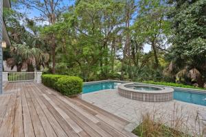 a backyard with a pool and a wooden deck at 340 Low Oak Woods Road by Akers Ellis Rentals in Kiawah Island