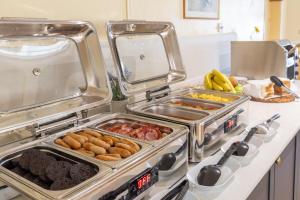 a kitchen with several trays of food on a counter at The Bein Inn Hotel & Restaurant in Glenfarg