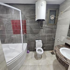 Un baño con un inodoro blanco y un lavabo. en الاقصر, en Luxor