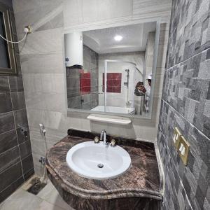 un baño con lavabo y espejo en الاقصر, en Luxor