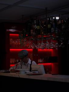 Un hombre sentado en una mesa en un bar con una computadora portátil. en Hotel Helene, en Medellín