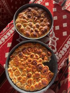 two pans of food sitting on top of a table at Wadi Rum stael Luxury Camp in Wadi Rum