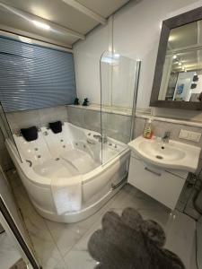 イスタンブールにあるDream Flatの大きな浴槽と洗面台のあるバスルーム
