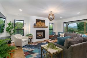 Una sala de estar con un sofá y una chimenea. en Mountain Retreat Game Rm Hot Tub FirePit Mtn Views, en Mars Hill