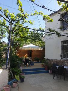 un patio con un tavolo e un ombrellone di Guesthouse Rusto a Gjirokastër