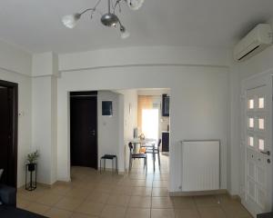 a white living room with a table and chairs at Vicky's house in Olympiada