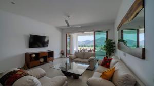 un salon avec deux canapés et une télévision dans l'établissement El Tular 002 2 bedroom villa 7 mins walk from La Ropa beach, à Zihuatanejo