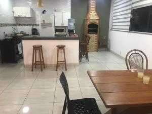 a kitchen with a counter and a table and chairs at casa Hamburgo in Búzios