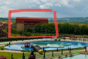a large swimming pool with a slide in front of a building at Bordeaux in Sângeorgiu de Mureș