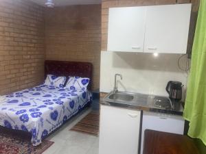 a small kitchen with a bed and a sink at SJ Kololi Apartments Senegambia Area in Sere Kunda