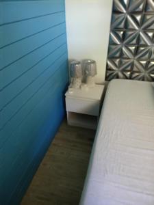 a bedroom with a bed and a blue wall at Douceur de la mer des caraibes in Sainte-Rose