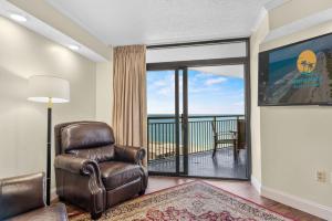 sala de estar con silla y balcón en Sand Dunes Resort Unit 1406 - Ocean View, en Myrtle Beach